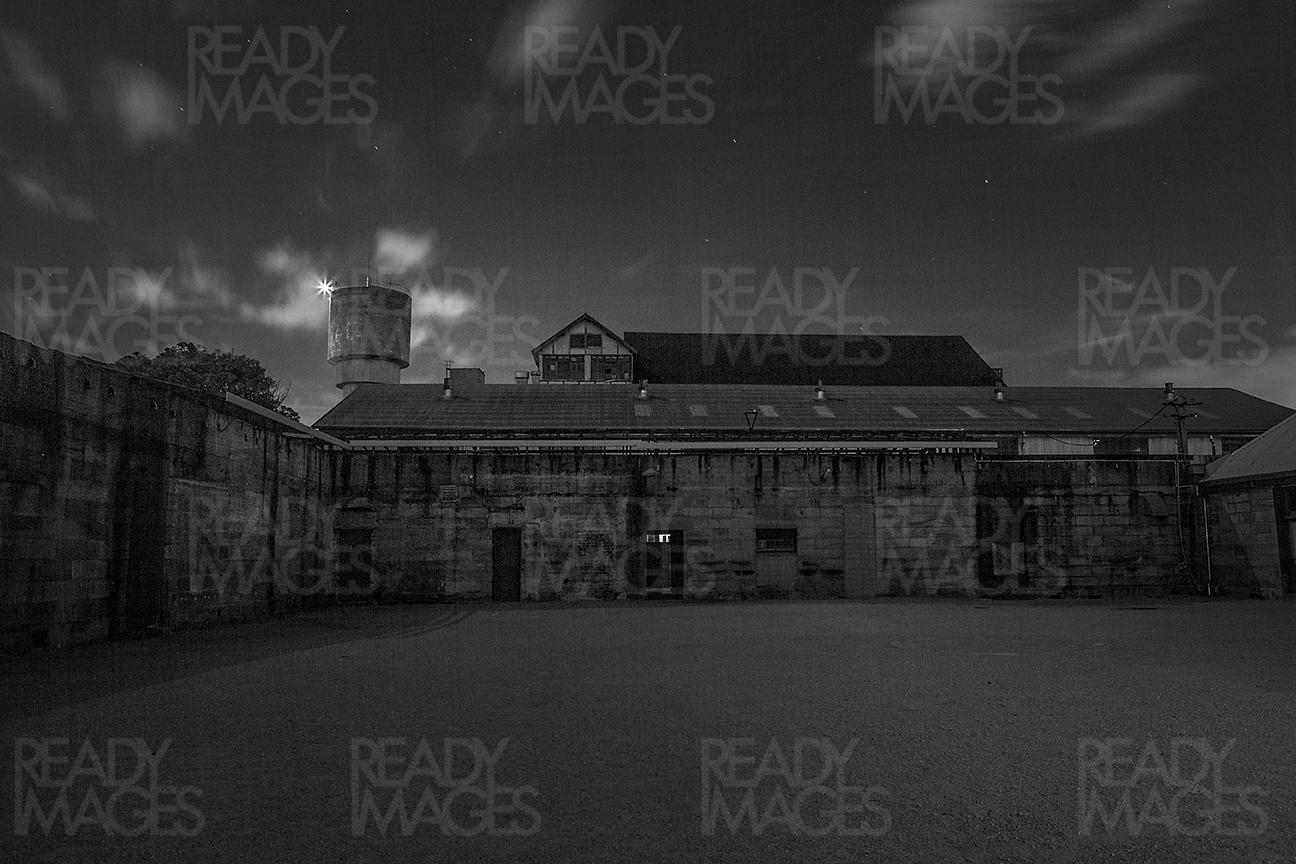 Black and white night photo of buildings in Convict Precinct of Cockatoo Island, Sydney, Australia.