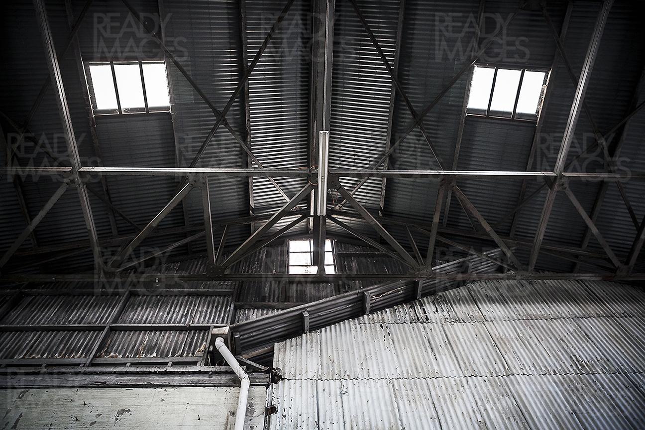 Monochrome photo looking up inside a building of Industrial Precinct showing metal cladding, roof, skylight and steel structure at Cockatoo Island, Sydney, Australia
