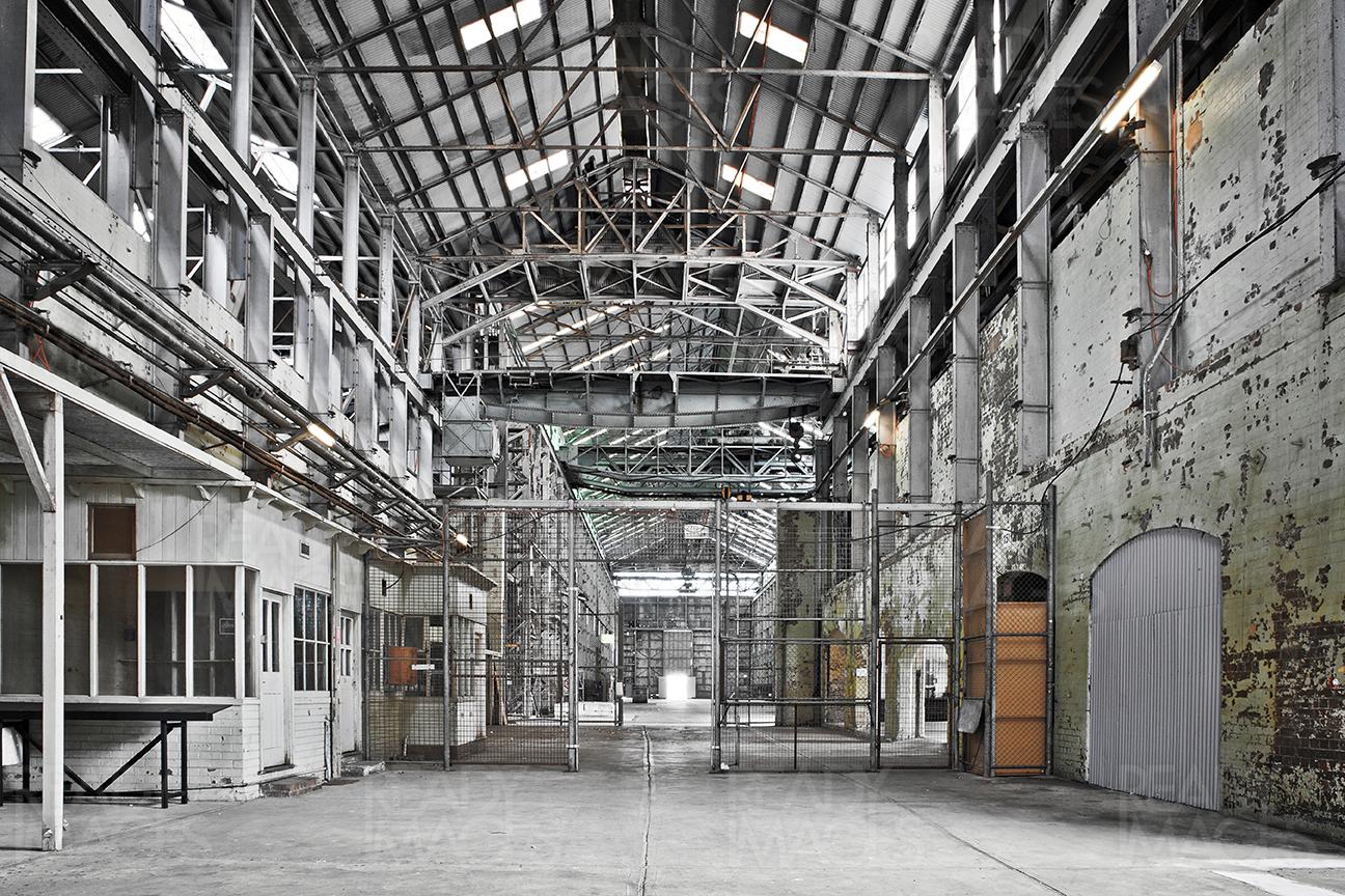One point perspective of an old building in industrial design precinct showing the vast volume of the space surrounded by metal cladding, roof, skylight and steel structure at Cockatoo Island, Sydney, Australia