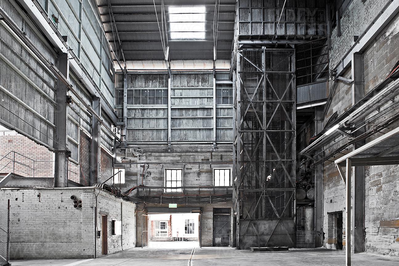Inside of an old building in industrial design precinct showing the high volume space surrounded by metal cladding, roof, skylight and steel structure at Cockatoo Island, Sydney, Australia
