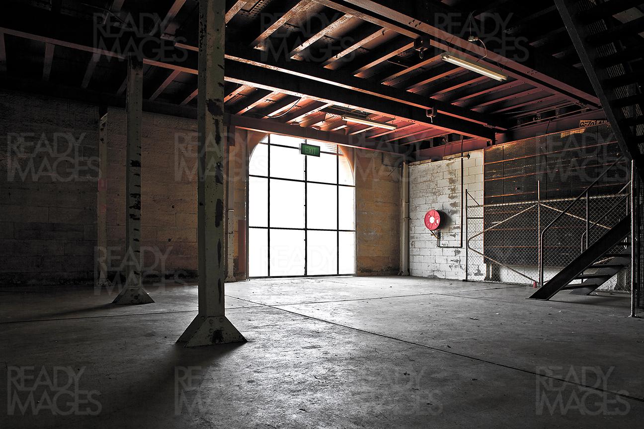 Bright light coming through a large glazed window highlighting red ceiling and concrete floor at Cockatoo Island, Sydney, Australia
