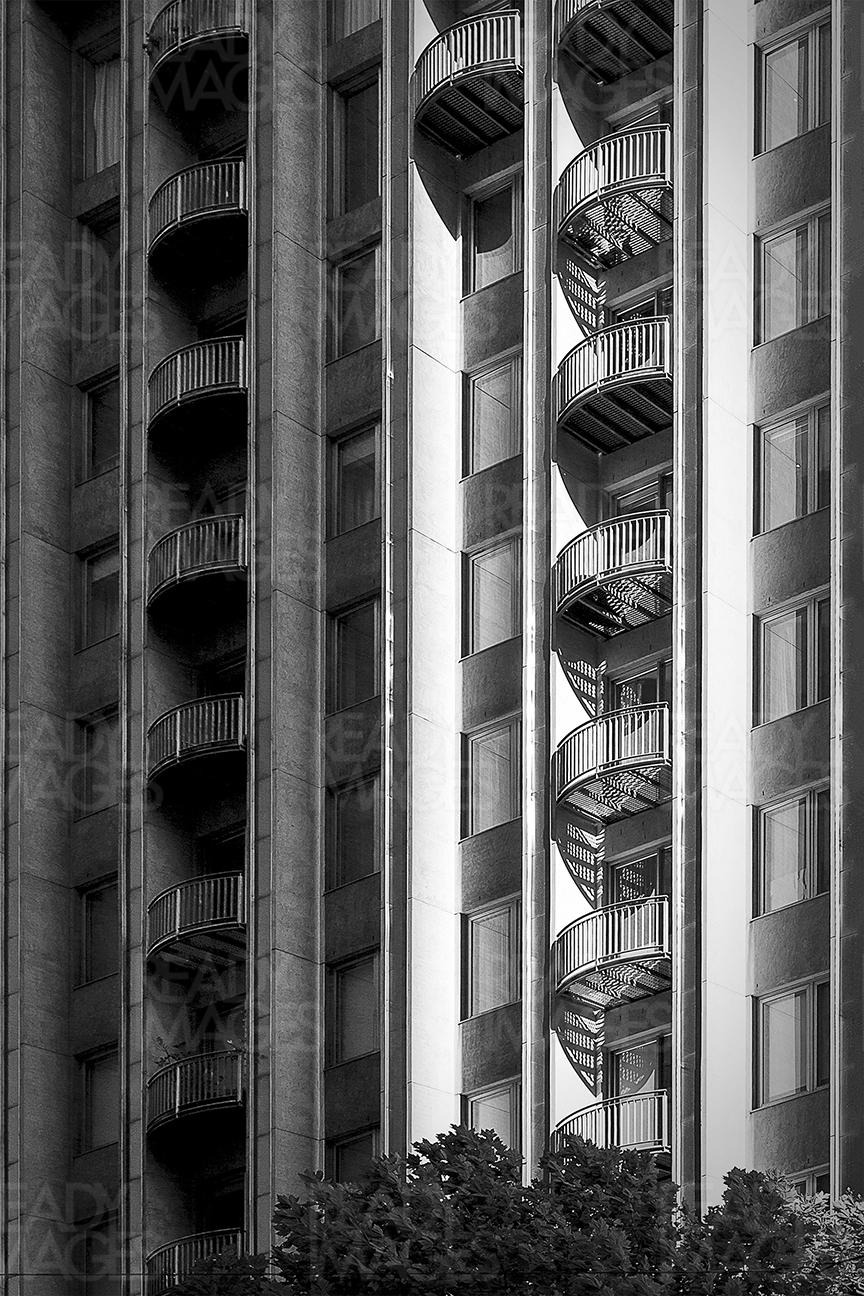 Black and white architectural image of a high-rise building facade with balconies
