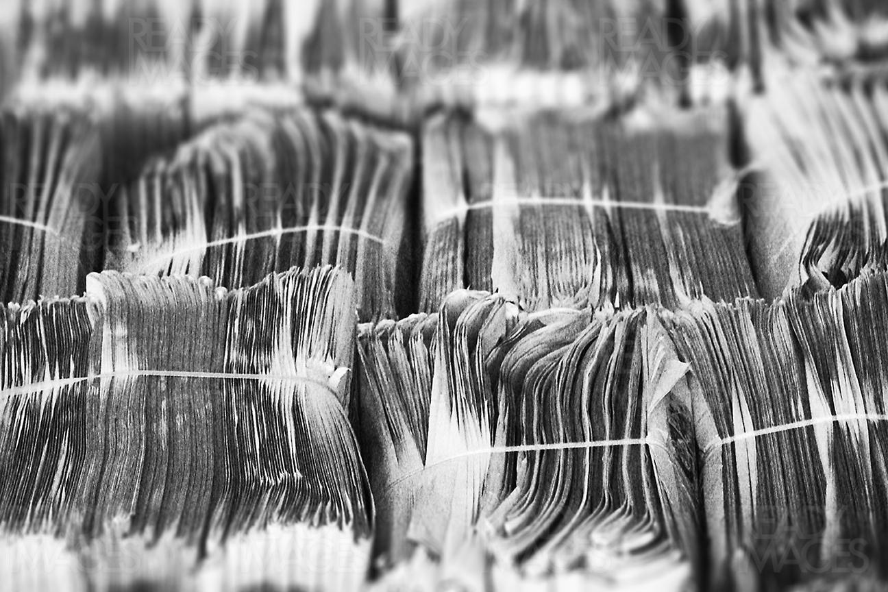 Black and white abstract image of a large pile of old newspapers stacked and arranged in an order