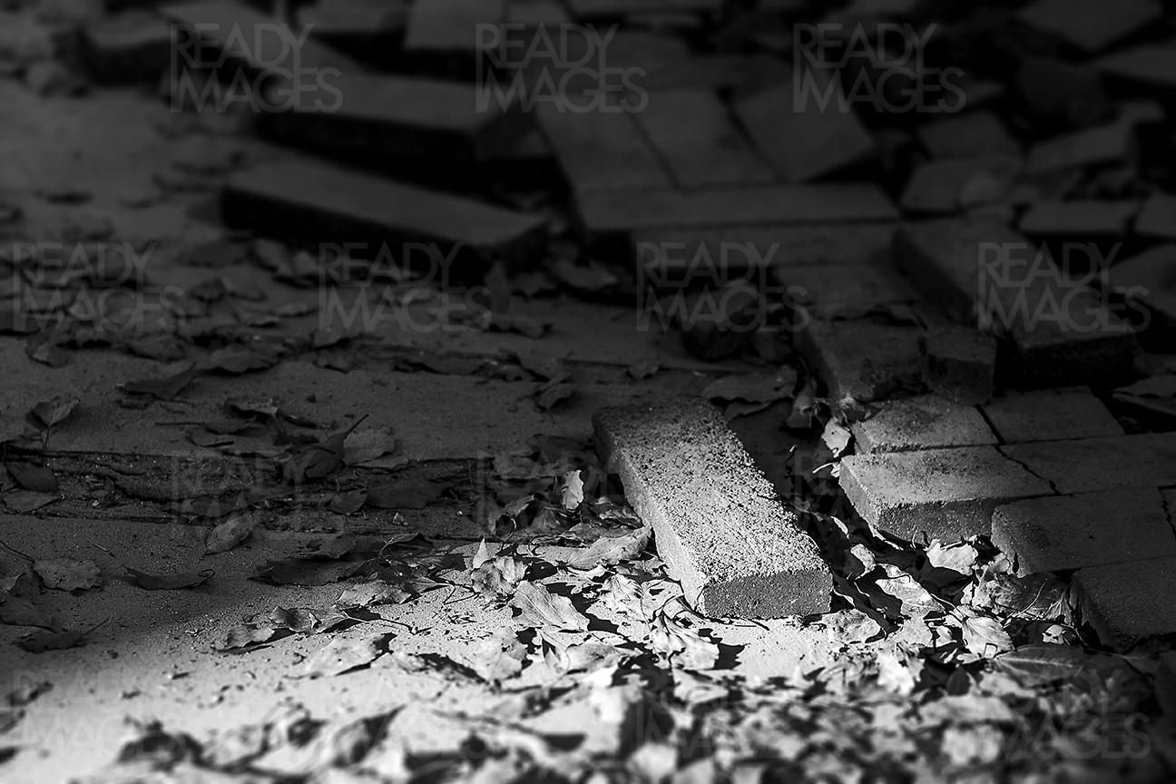 Black and white image of bricks lying around in an abandoned interior