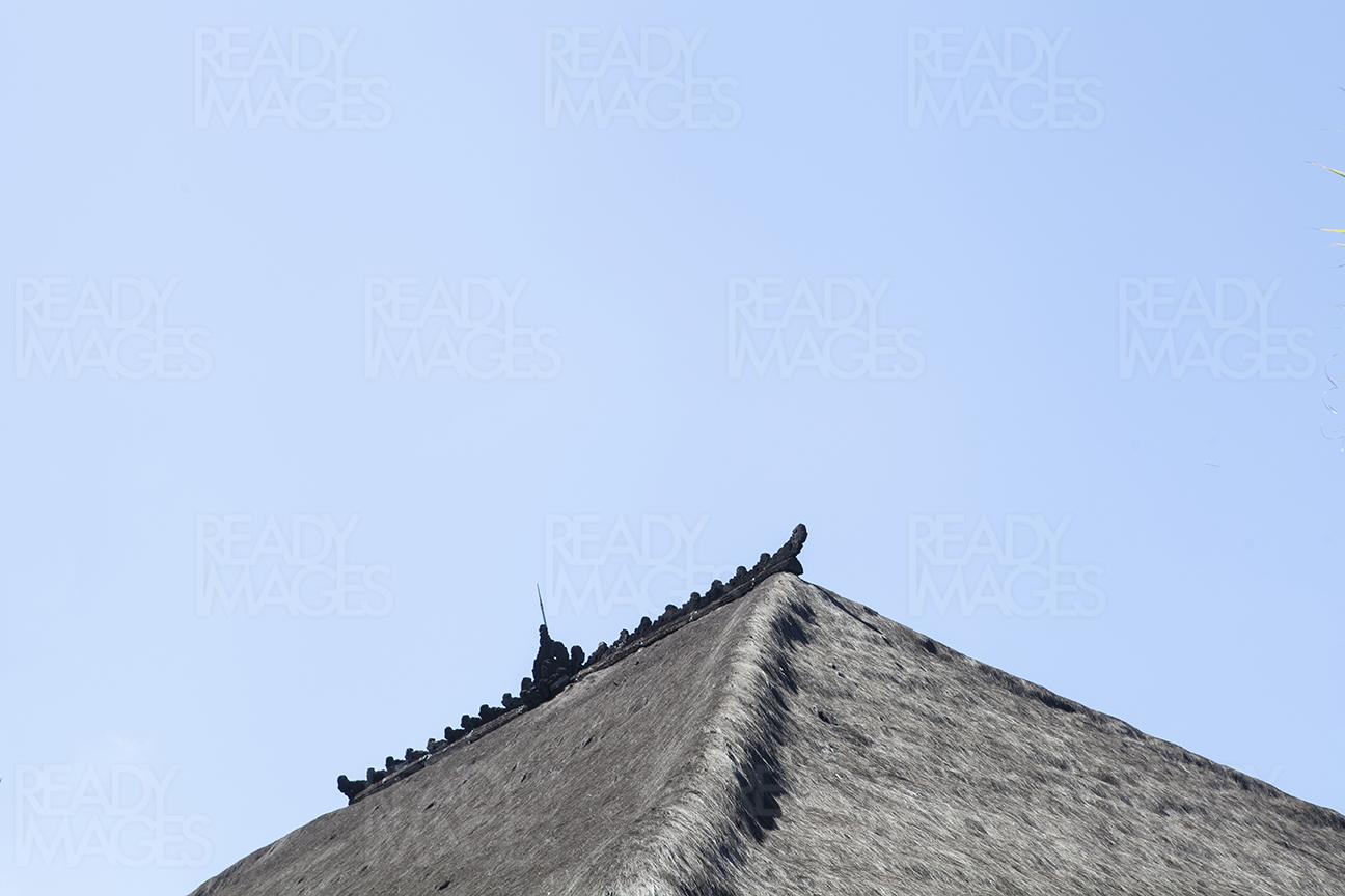 Image of a Traditional Balinese thatched roof detail built almost entirely of organic and local materials, taken on a clear blue sky