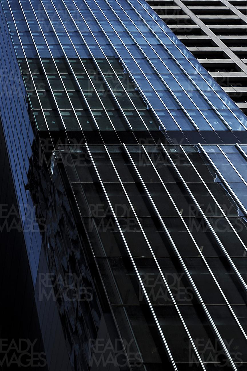 Low angle view, looking up at the abstract modern blue glass facade