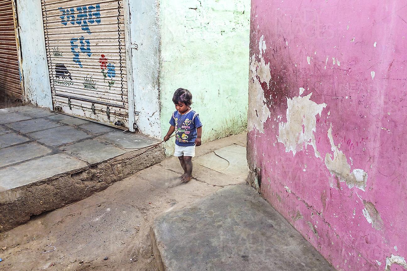 Little boy walking on the colourful narrow streets of Ahmedabad, India