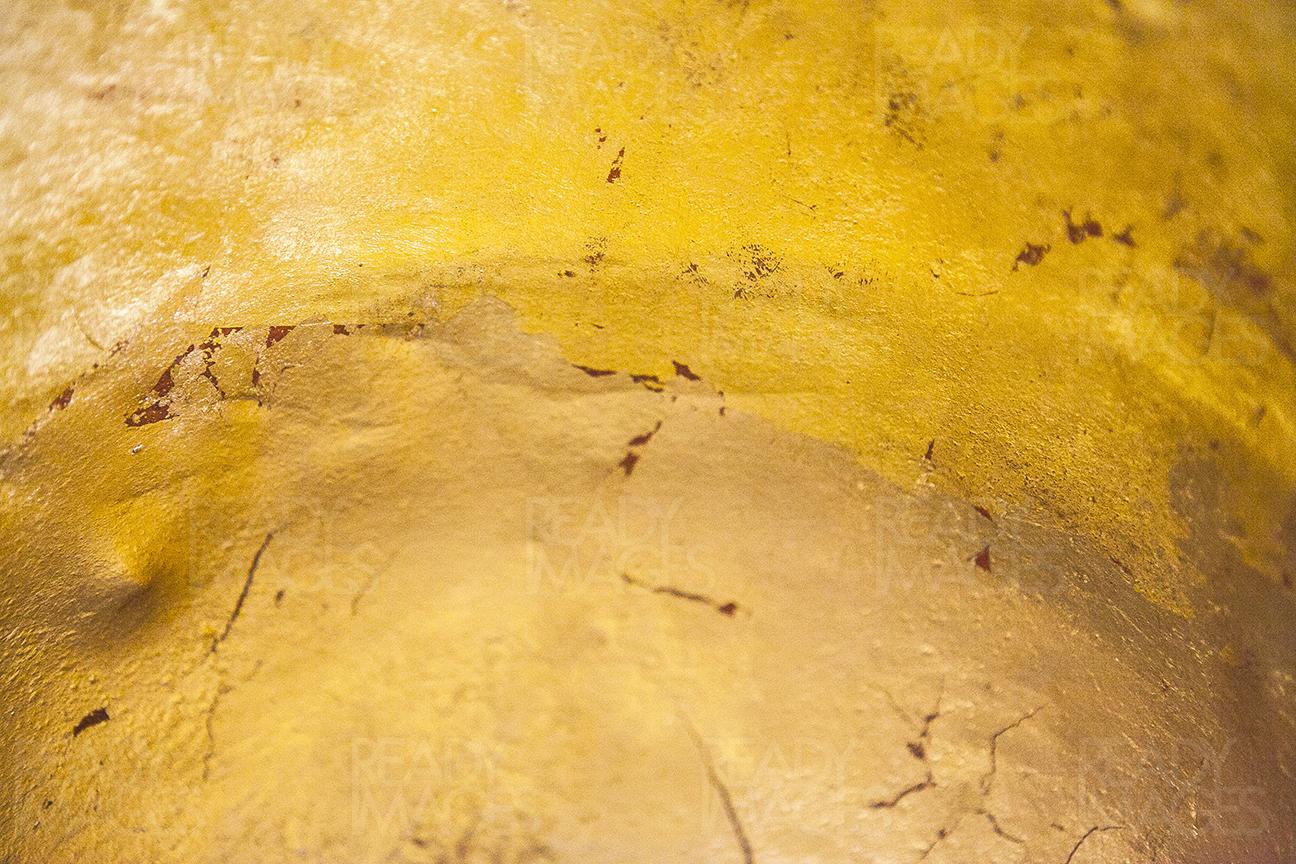 Close-up abstract image of shiny yellow paint on an old metal sheet