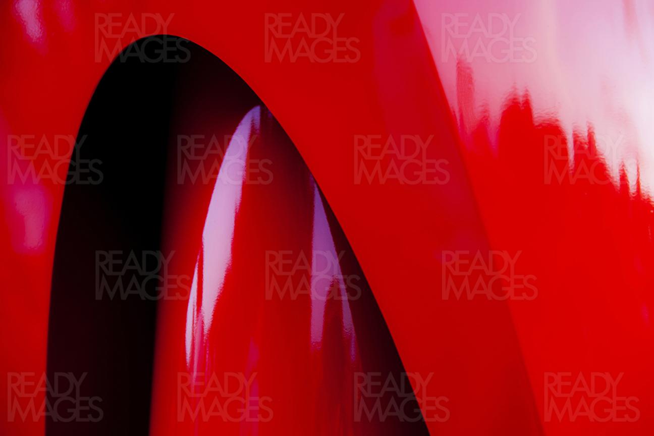 Close-up abstract image of a smooth shiny red painted structure