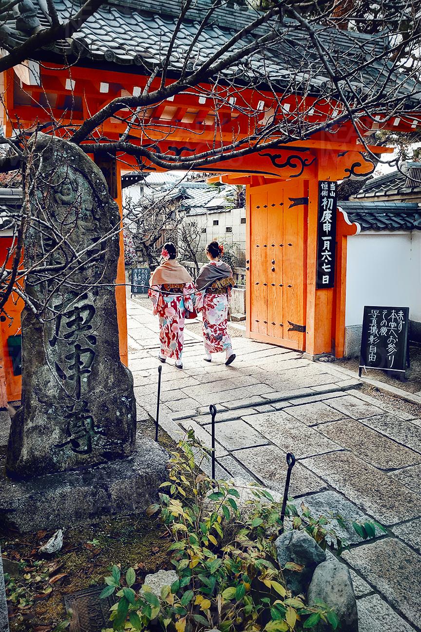 Girls in Kimonos walking through a gate of a temple in Gion