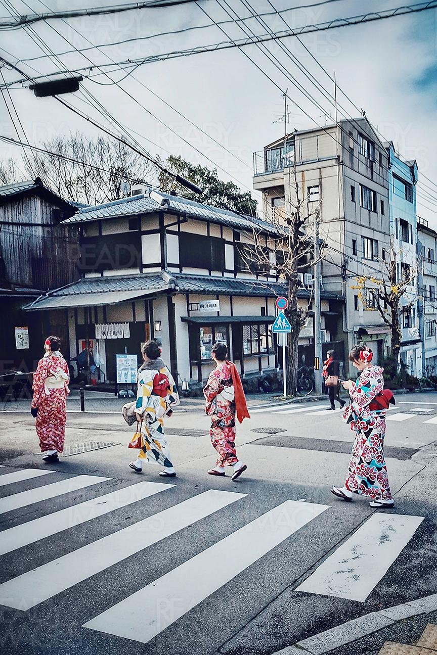 Tourists dressed in traditional Japanese clothes - Kimono, walking across the streets of Gion